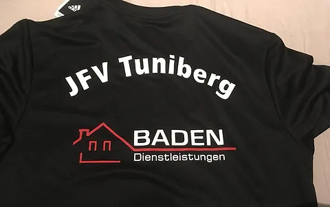 Schwarzes Sporttrikot mit dem Aufdruck 'JFV Tuniberg' und dem Logo 'Baden Dienstleistungen' darunter.
